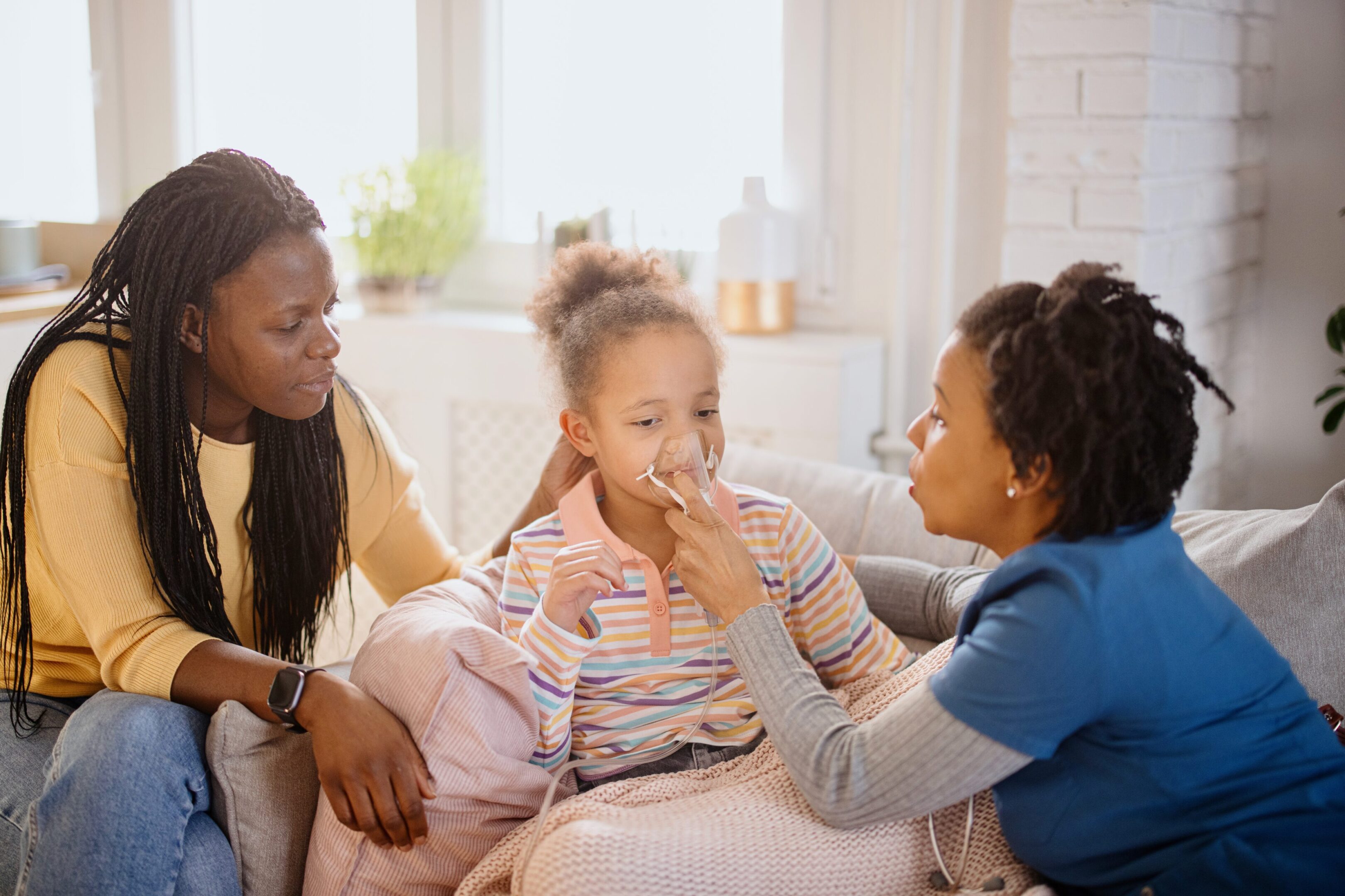 A black female doctor with her patient during a home visit medical appointment.