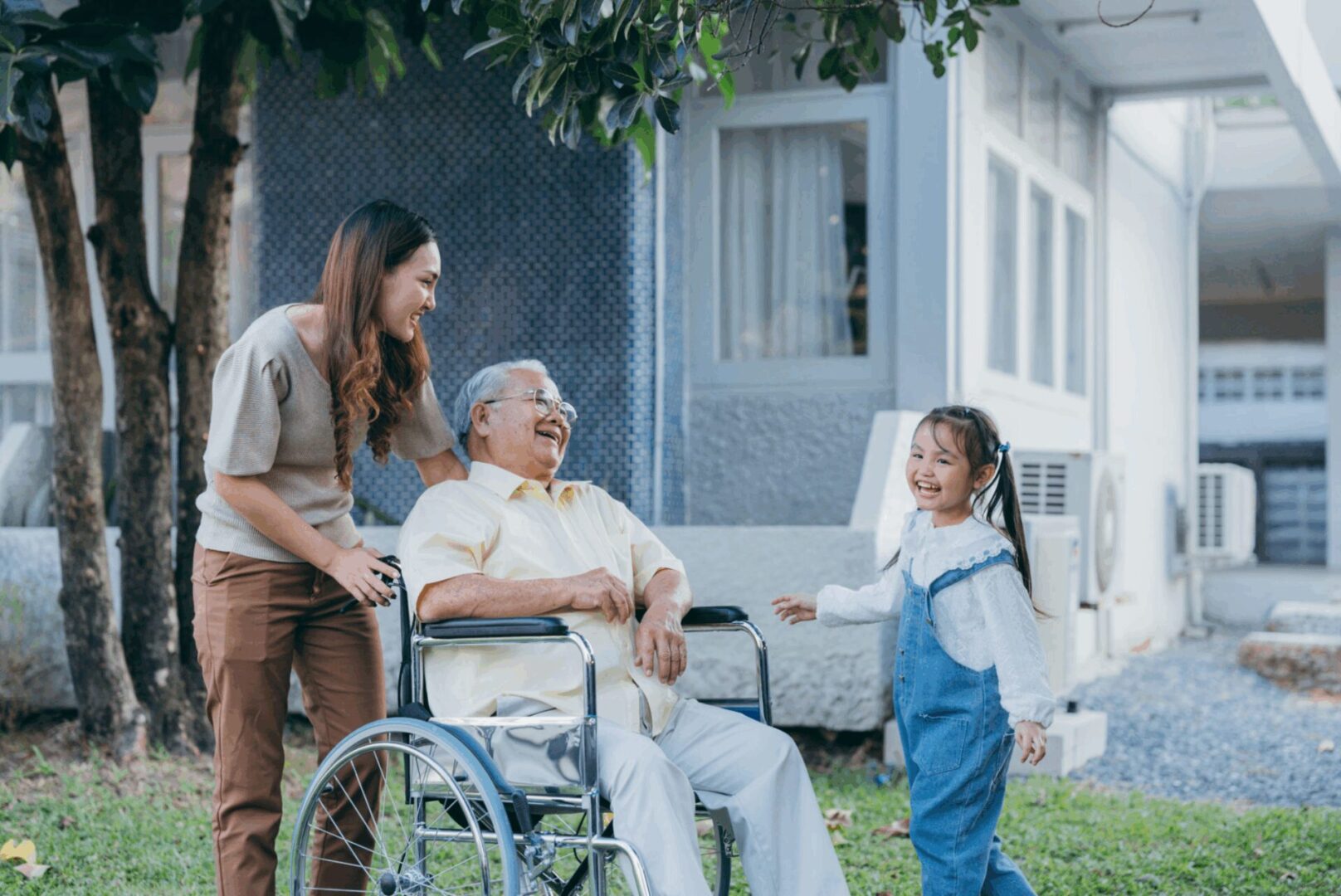 Happy family with senior man in wheelchair.
