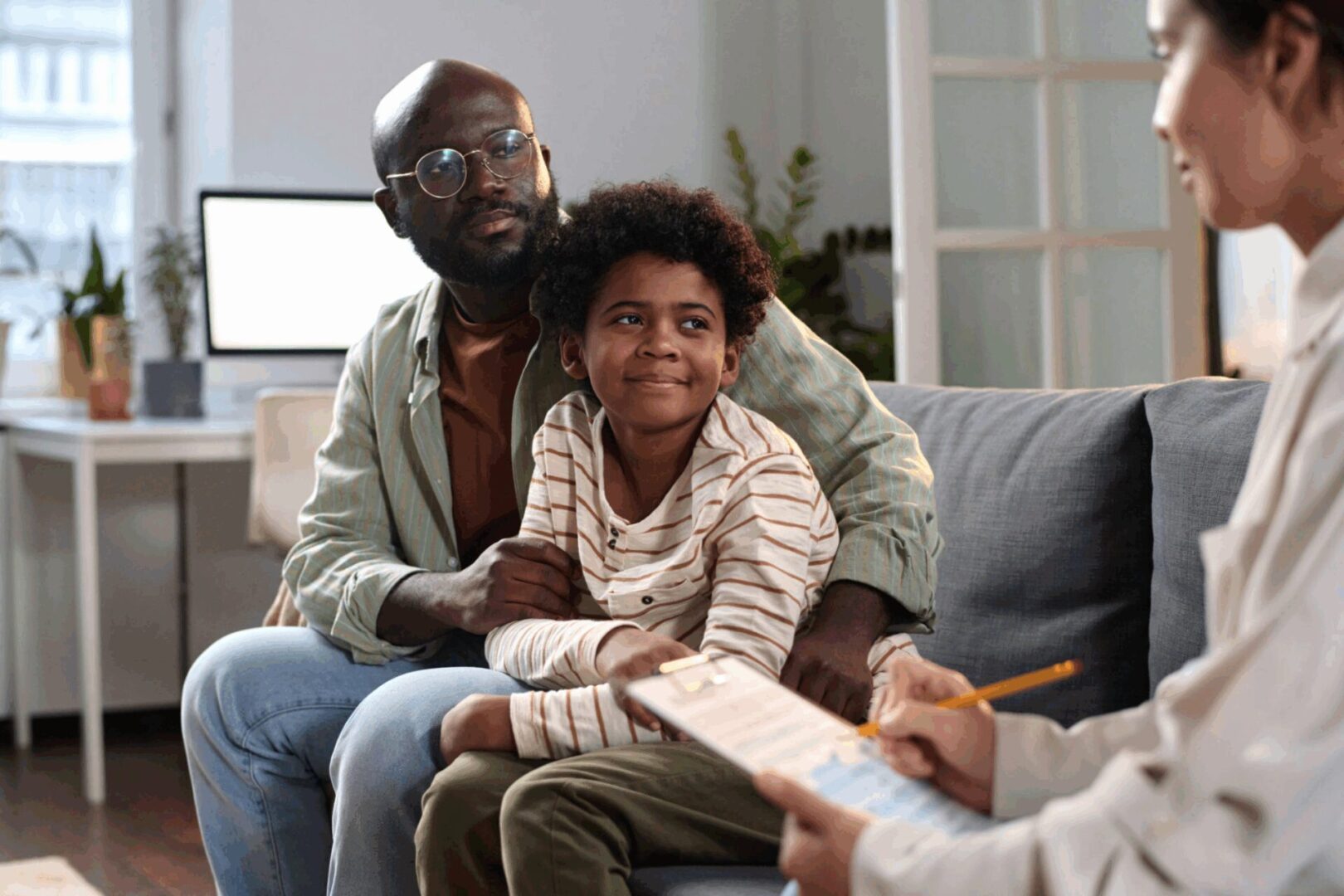 Family meeting with a therapist on couch.